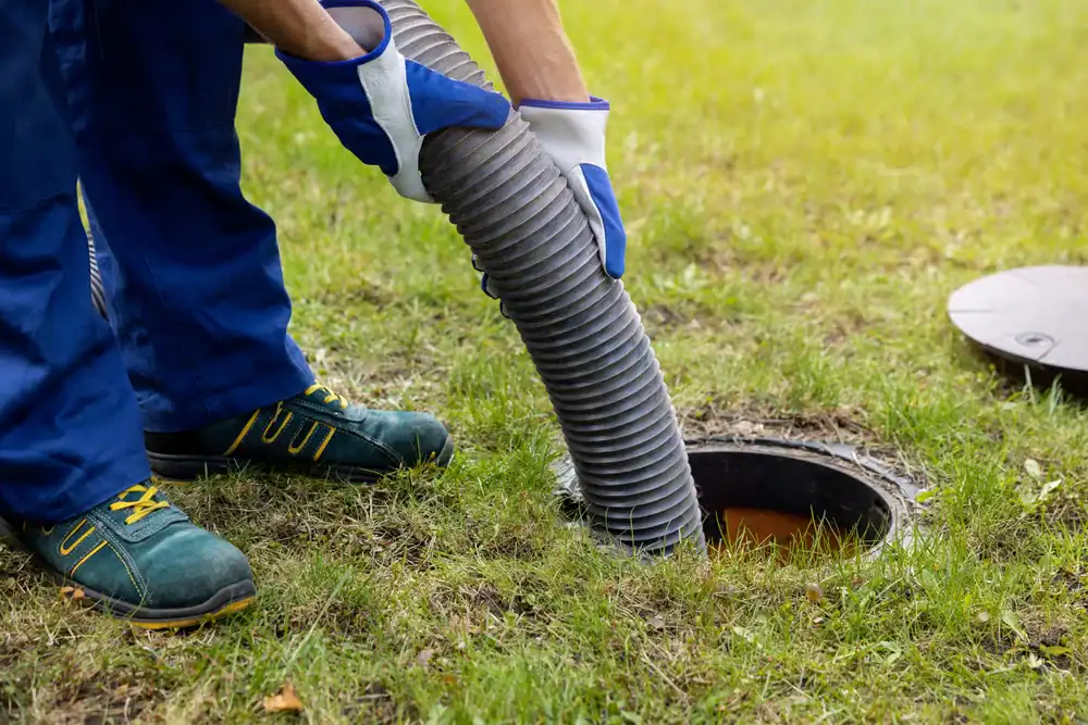 Septic tank maintenance worker inspecting and servicing a residential septic system in Cook County, Illinois, using professional equipment for All Rooter Hydro Jetting Experts